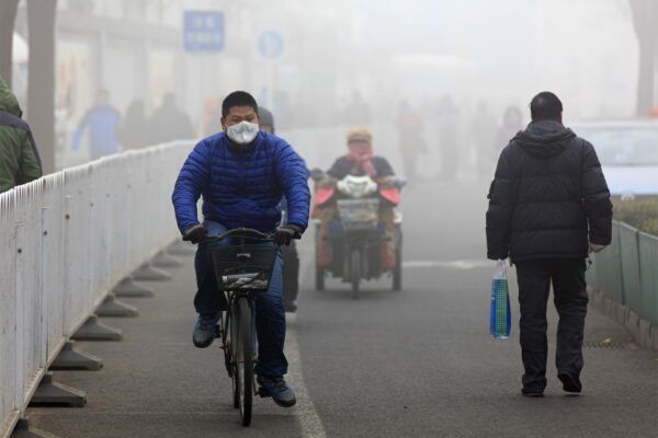 People walking and riding bikes in smog