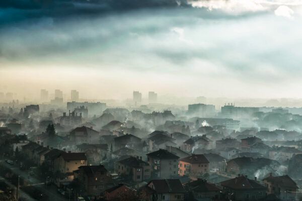A bird's eye view of a city surrounded in smog.