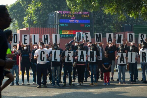 People hold up signs that spell out 'Delhi Demands Clean Air'