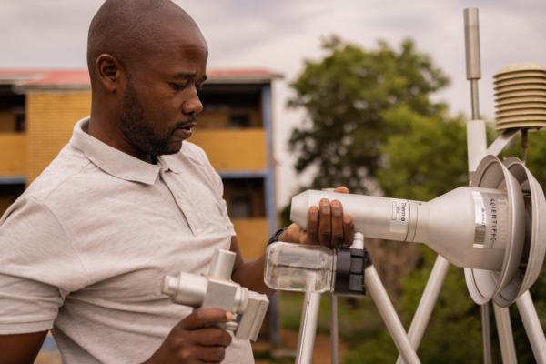 Image of technician, Harry Mhlanga checking and cleaning the inlets of the ambient air quality monitoring station managed by South African Weather Services in Diepkloof, Johannesburg.