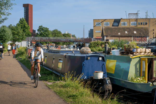 People walk and cycle along a canal in Hackney Wick, London, UK. Credit: iStock