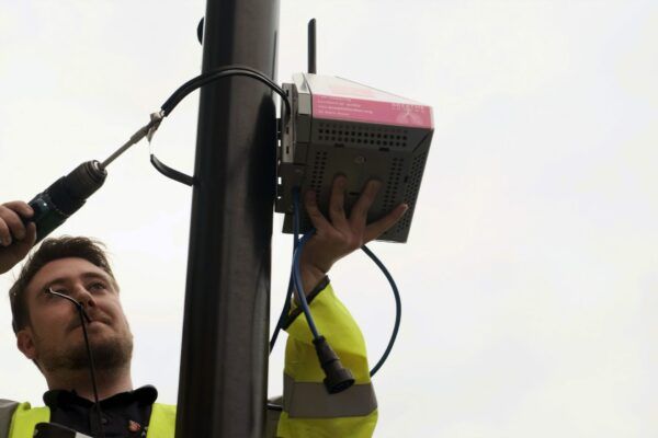 Man installing an air pollution pod in London