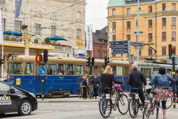 Traffic in city center. Tram, people, taxi and bike riders. Stockholm, Sweden