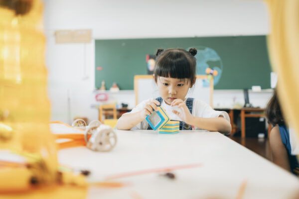 Preschool children playing with teaching aids in classroom